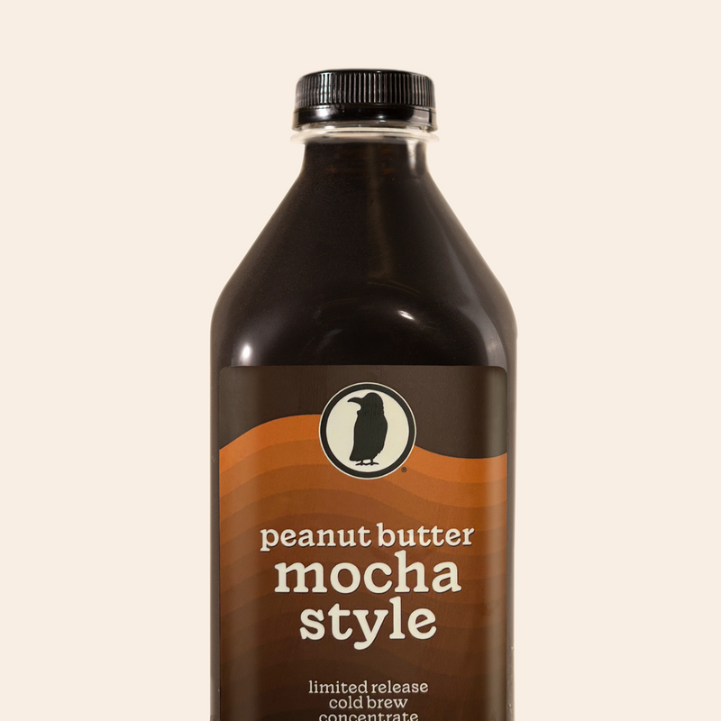 Glass bottle of Rook Coffee’s Peanut Butter Mocha Style limited release cold brew with a rich brown and orange label.