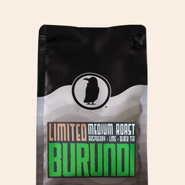 Rook Coffee bag with ' Limited Burundi' branding and "medium roast, raspberry, lime, black tea" on the label on a beige background.