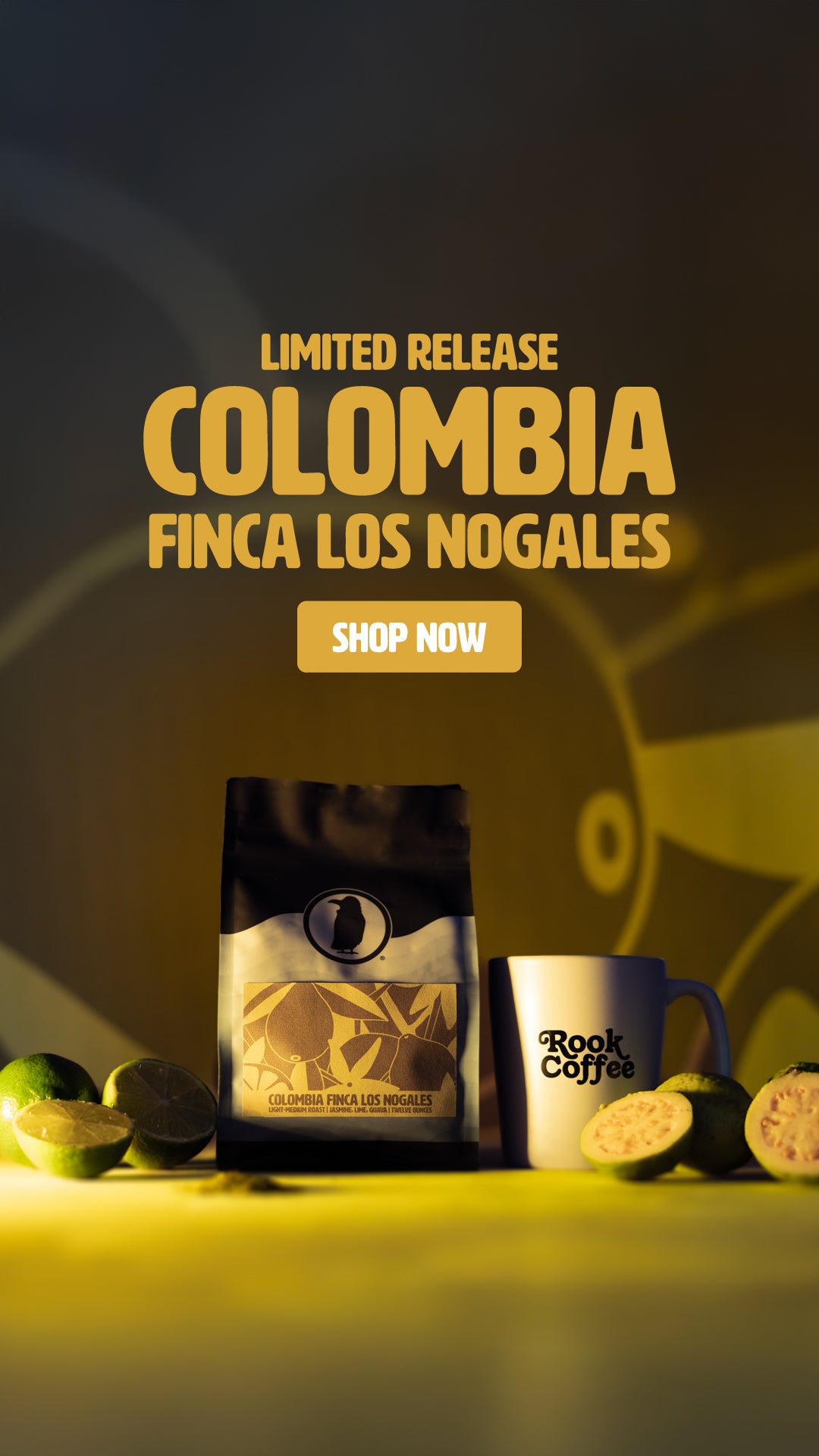 Promotional image for Colombia Finca Los Nogales limited release coffee. The photo shows a coffee bag with a yellow and brown label, a white Rook Coffee mug, fresh limes, and sliced guava on a yellow surface. Bold text above the products reads: 'Limited Release Colombia Finca Los Nogales' with a 'Shop Now' button below.