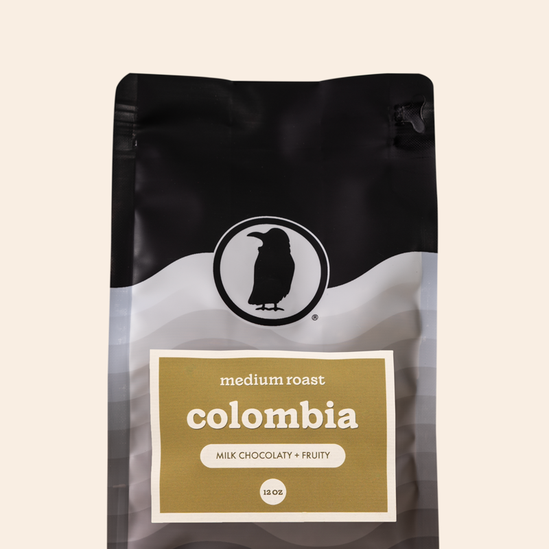 Packaging of a 12-ounce bag of medium roast coffee labeled 'Colombia, Milk Chocolaty + Fruity,' featuring the Rook Coffee logo at the top. 