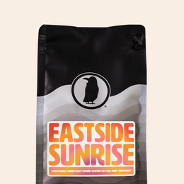 Rook Coffee’s Eastside Sunrise coffee bag featuring a colorful orange, pink, and yellow label; medium roast from Colombia with key lime, honey, and green grape notes.