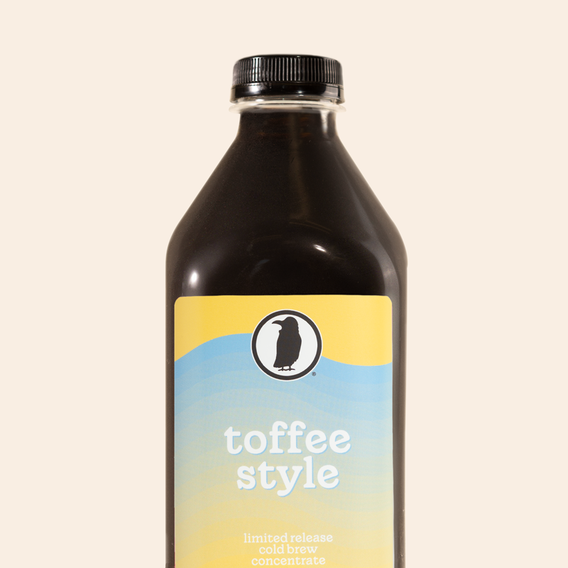 A 32-ounce bottle of Rook Coffee’s Toffee Style limited release cold brew concentrate with a yellow and light blue label featuring the Rook Coffee logo. The label reads “toffee style” and “limited release cold brew concentrate.”