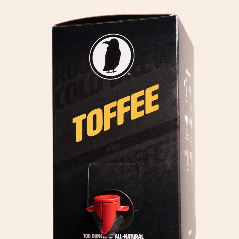 Boxed Rook Coffee cold brew with a black package, yellow ‘Toffee’ text, and the Rook Coffee bird logo near the top. A red dispensing spout is visible on the front.