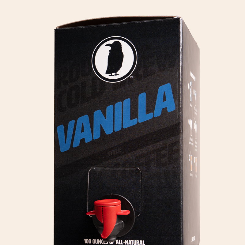 Boxed Rook Coffee vanilla cold brew with a black package, blue ‘Vanilla’ text, and the Rook Coffee bird logo near the top. A red dispensing spout is visible on the front.