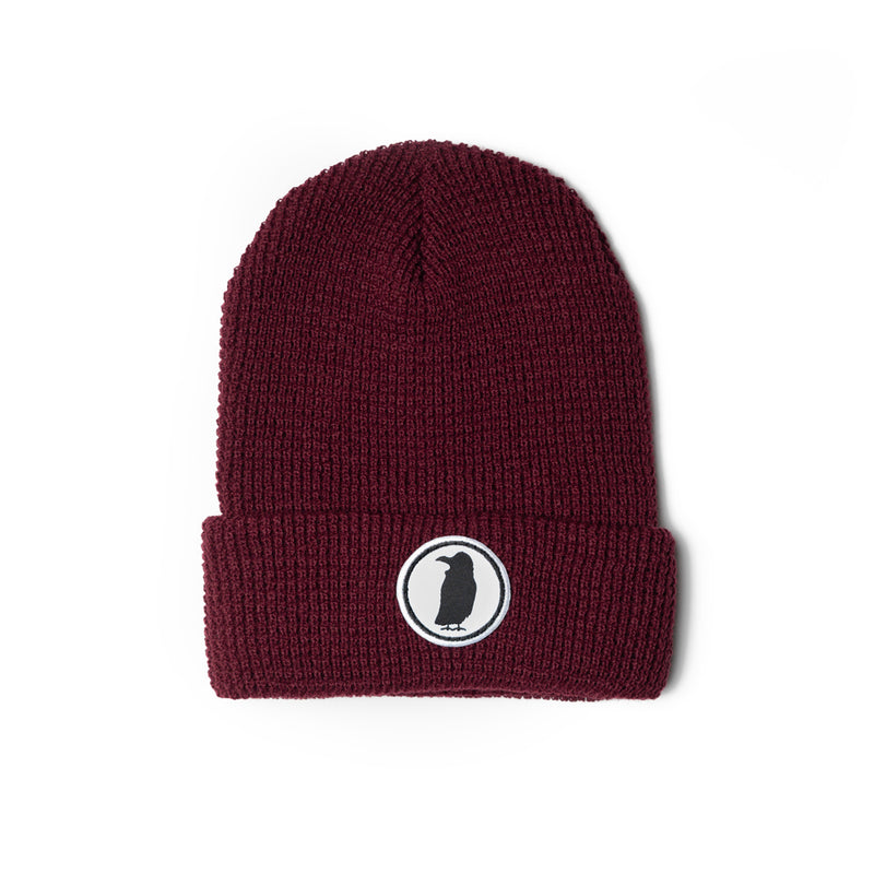 A maroon knit beanie with a Rook Coffee logo on the brim