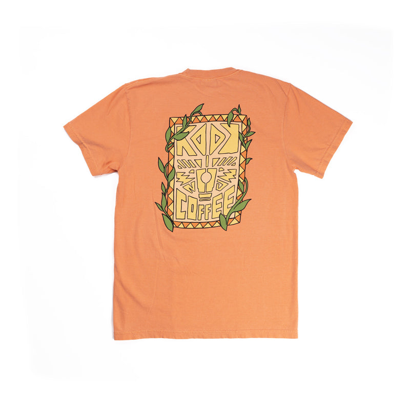 An orange tee shirt with a yellow, orange, peach and green tiki design with the words 'Rook Coffee' in it.