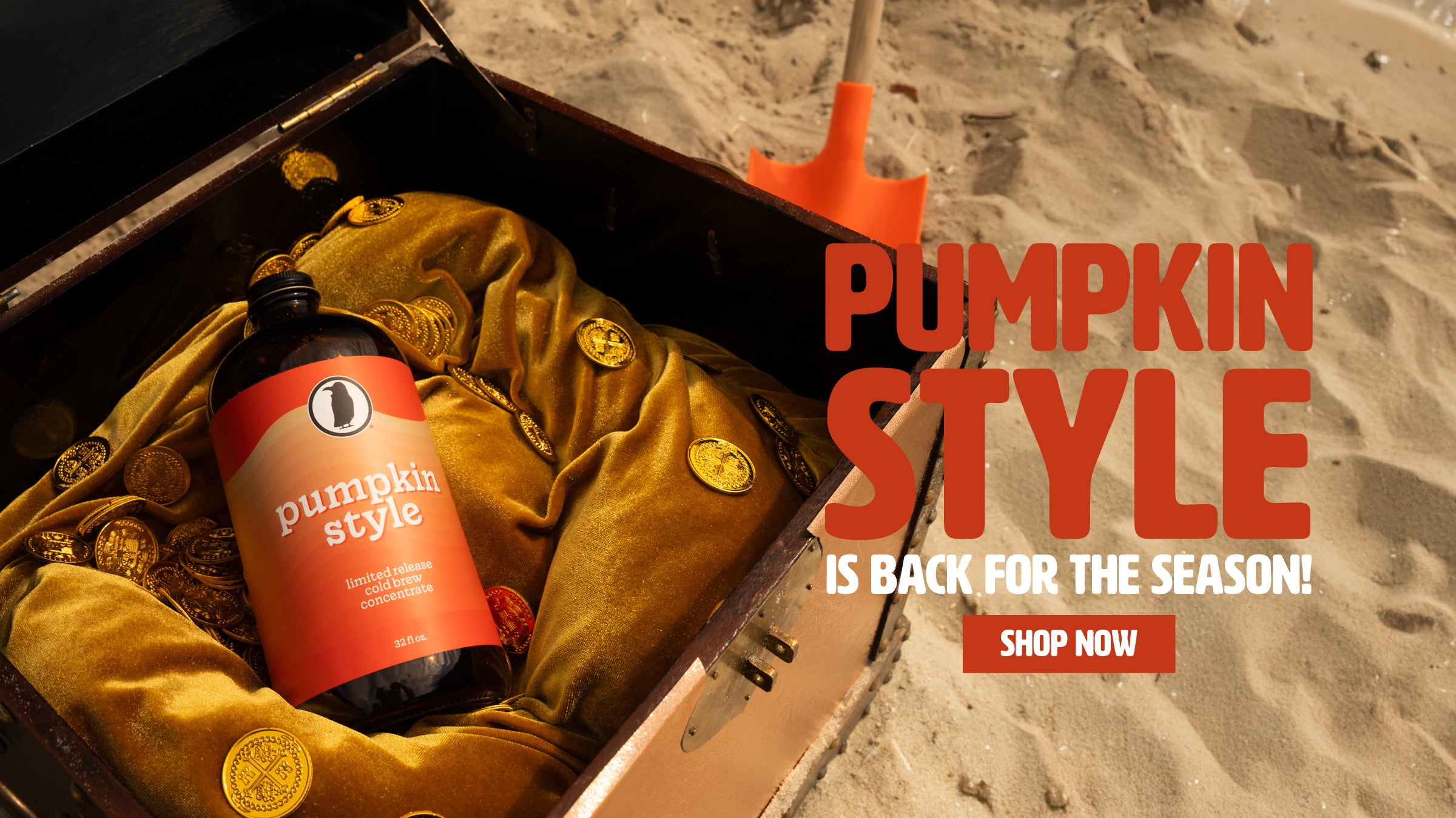 On a sandy beach, a treasure chest filled with gold coins and lined with gold fabric holds a 32-ounce bottle of Rook Coffee Pumpkin Style Cold Brew Concentrate. Next to it, large bold text reads “Pumpkin Style is back for the season! Shop Now.”